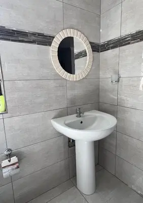 a bathroom with a sink and a mirror at The Ripanga Nest in Nelspruit