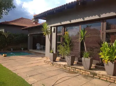 a house with potted plants sitting outside of it at Dream Retreat Pecanwood Golf Estate in Hartbeespoort
