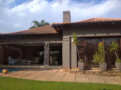 a house with a patio with plants in the yard at Dream Retreat Pecanwood Golf Estate in Hartbeespoort