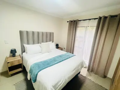 a bedroom with a large white bed and a window at U4 KT View in Midrand