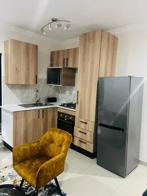 a kitchen with a chair and a stainless steel refrigerator at U4 KT View in Midrand