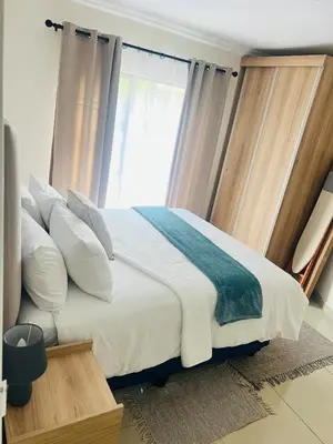 a bedroom with a bed with white pillows and a window at U4 KT View in Midrand