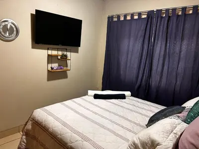 a bedroom with a bed with a flat screen tv at Castle in the Capital City 3-Beds in Pretoria