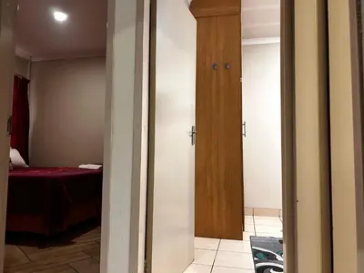 a hallway with two doors and a room with a bed at Castle in the Capital City 3-Beds in Pretoria