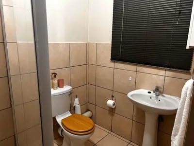a bathroom with a toilet and a sink at Castle in the Capital City 3-Beds in Pretoria