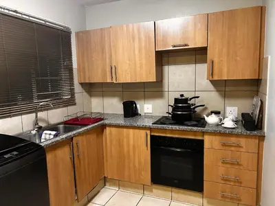a kitchen with wooden cabinets and a stove top oven at Castle in the Capital City 3-Beds in Pretoria