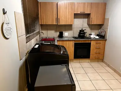 a small kitchen with a sink and a stove at Castle in the Capital City 3-Beds in Pretoria