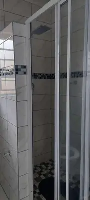 a shower with a glass door in a bathroom at Emlomo logde in Ermelo
