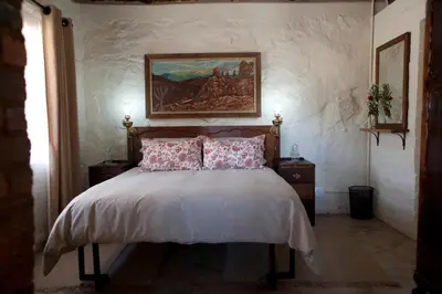 a bedroom with a bed with a painting on the wall at Stone Cottage in Tierpoort