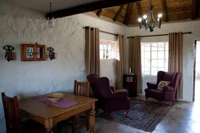 a living room with a table and two chairs at Stone Cottage in Tierpoort