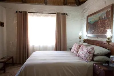 a bedroom with a large bed with a window at Stone Cottage in Tierpoort