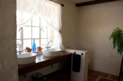 two sinks in a bathroom with a window at Stone Cottage in Tierpoort