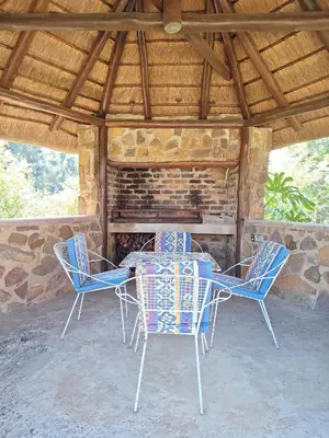a table and chairs in front of a fireplace at Ouma se Huis in Tierpoort