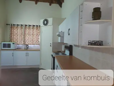 a kitchen with white cabinets and a counter top at Ouma se Huis in Tierpoort