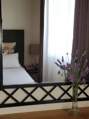 a bedroom with a bed with a vase of flowers at Ouma se Huis in Tierpoort