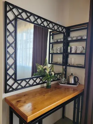 a mirror on a wall with a wooden table at Ouma se Huis in Tierpoort