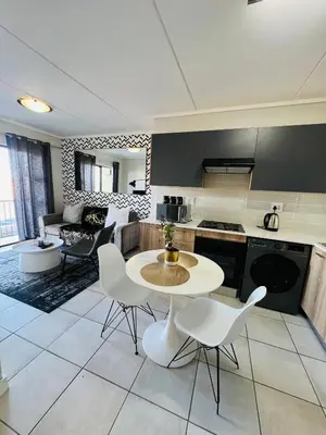 a kitchen and living room with a table and chairs at The Lagoon in Pretoria