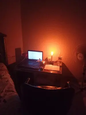 a desk with a laptop computer on it in a dark room at Charming 3 - Bedroom Home in Mangweni