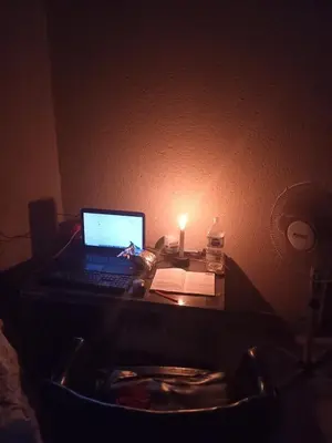 a laptop computer sitting on a desk in a dark room at Charming 3 - Bedroom Home in Mangweni
