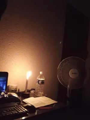 a desk with a laptop computer and a fan at Charming 3 - Bedroom Home in Mangweni