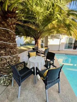 a patio with a table and chairs next to a pool at Vinorisa Spa & Lodge in Pretoria
