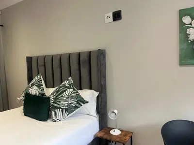 a bed with green and white pillows on it at Vinorisa Spa & Lodge in Pretoria