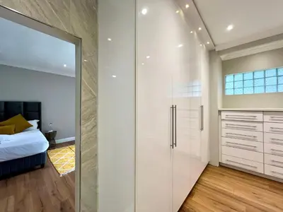a glass shower in a bedroom with a bed at Vinorisa Spa & Lodge in Pretoria