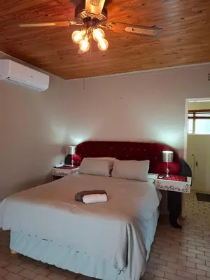 a bedroom with a large bed with a ceiling at Mountain View Cottage in Barberton