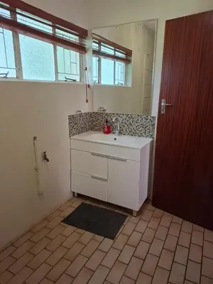 a bathroom with a white sink and a mirror at Mountain View Cottage in Barberton