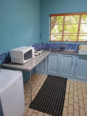a kitchen with a microwave on top of a counter at Mountain View Cottage in Barberton