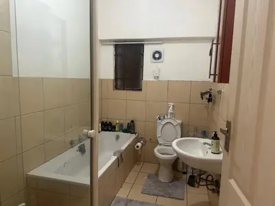 a bathroom with a tub and a toilet and a sink at Kwa Ndosi in Polokwane