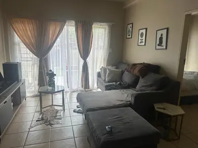 a living room with a couch in front of a window at Kwa Ndosi in Polokwane