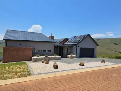a large white house with a brick driveway at Ironwood Manor in Dullstroom