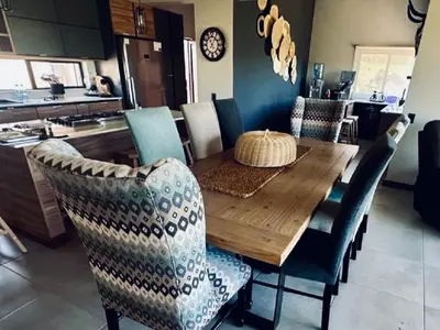 a dining room with a wooden table and chairs at Ironwood Manor in Dullstroom