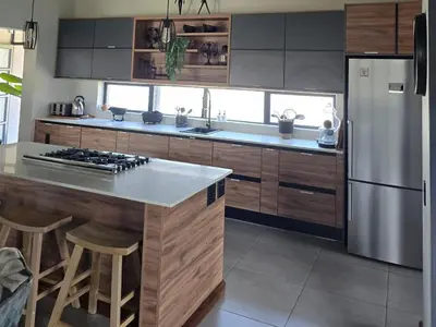 a kitchen with a stainless steel refrigerator and wooden cabinets at Ironwood Manor in Dullstroom