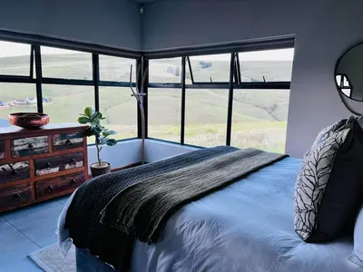 a bedroom with a bed with a large window at Ironwood Manor in Dullstroom