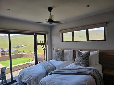 two beds in a room with a window at Ironwood Manor in Dullstroom