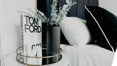 a table with two vases with flowers and a book at The Blyde Crystal Lagoon Apartment in Pretoria