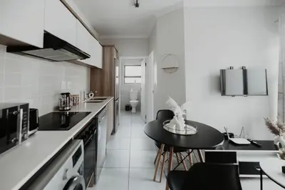 a kitchen with a table and chairs in a room at The Blyde Crystal Lagoon Apartment in Pretoria