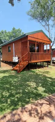a large wooden cabin with a large deck at Amatava Lodge in Mokopane