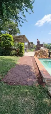 a brick walkway next to a swimming pool at Amatava Lodge in Mokopane