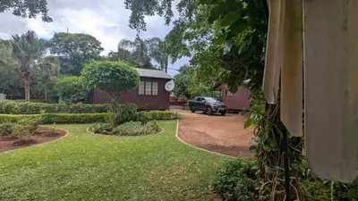 a house with a car parked in front of a yard at Koshys Haven at Kruger in Malelane