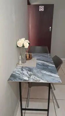 a blue marble table with a vase of flowers on it at Koshys Haven at Kruger in Malelane