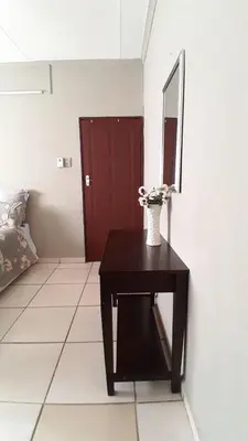 a room with a table with a vase of flowers on it at Koshys Haven at Kruger in Malelane