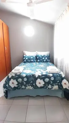 a bedroom with a bed with a blue comforter at Koshys Haven at Kruger in Malelane