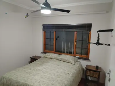 a bedroom with a bed and a ceiling fan at Wakanda on Hartbeespoort Dam in Hartbeespoort