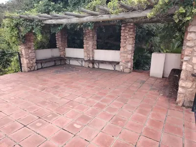 a patio with a brick floor and a pergola at Wakanda on Hartbeespoort Dam in Hartbeespoort