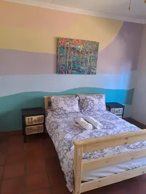 a bedroom with a bed and a painting on the wall at Wakanda on Hartbeespoort Dam in Hartbeespoort