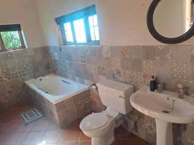 a bathroom with a tub and a toilet and a sink at Wakanda on Hartbeespoort Dam in Hartbeespoort