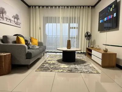 a living room with a couch and a table at Ambience Defined in Randjesfontein